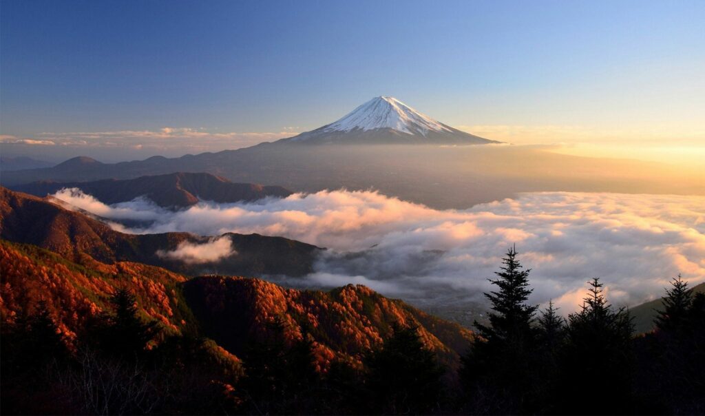 Snow-covered Mt. Fuji, a sea of clouds, and a climbing group